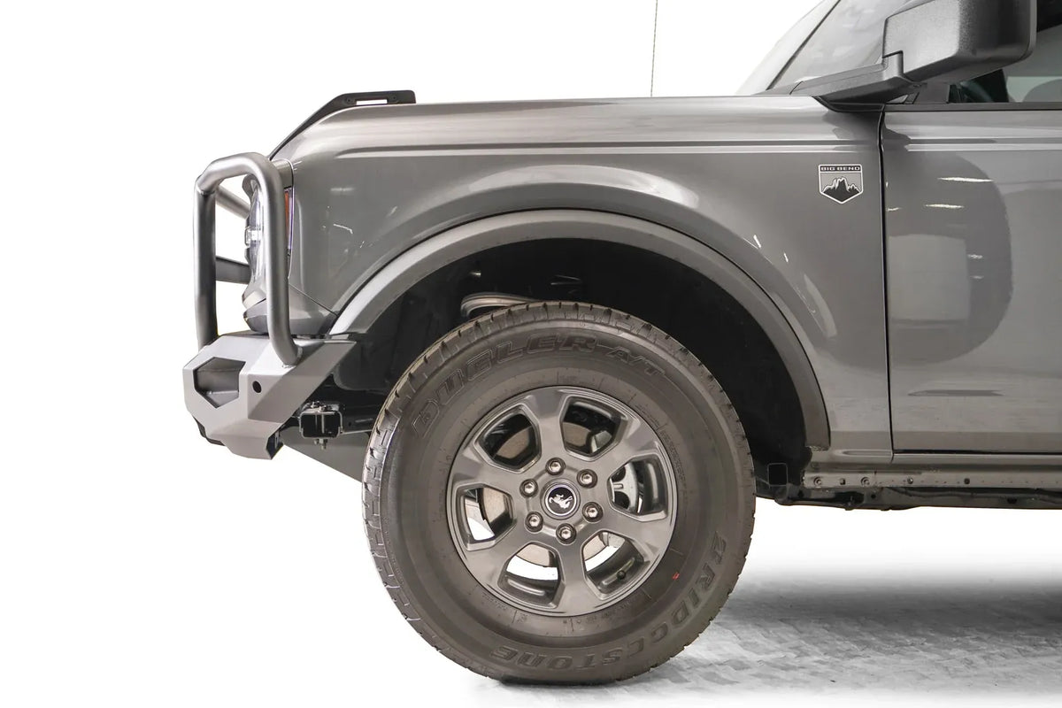 Fab Fours Matrix front bumper with full guard on a gray Ford Bronco, close-up of the driver-side bumper end, showing the guard upright, end cap and tire clearance