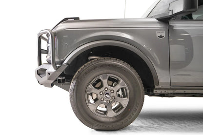Fab Fours Matrix front bumper with full guard on a gray Ford Bronco, close-up of the driver-side bumper end, showing the guard upright, end cap and tire clearance