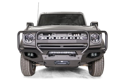 Fab Fours Matrix front bumper with full guard on a gray Ford Bronco, straight-on front studio view, showing the full grille guard, center light bar and winch fairlead