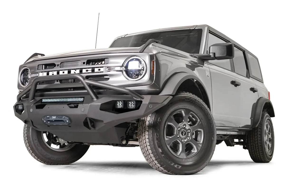 Fab Fours Matrix front bumper with pre-runner guard on a gray Ford Bronco, front driver-side three-quarter studio view, showing the pre-runner hoop, light bar and winch fairlead