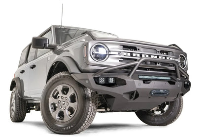 Fab Fours Matrix front bumper with pre-runner guard on a gray Ford Bronco, front passenger-side three-quarter studio view, showing the pre-runner hoop, light bar and cube light pods