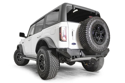 Fab Fours Premium rear bumper on a white Ford Bronco with tailgate-mounted spare tire, driver-side rear three-quarter view