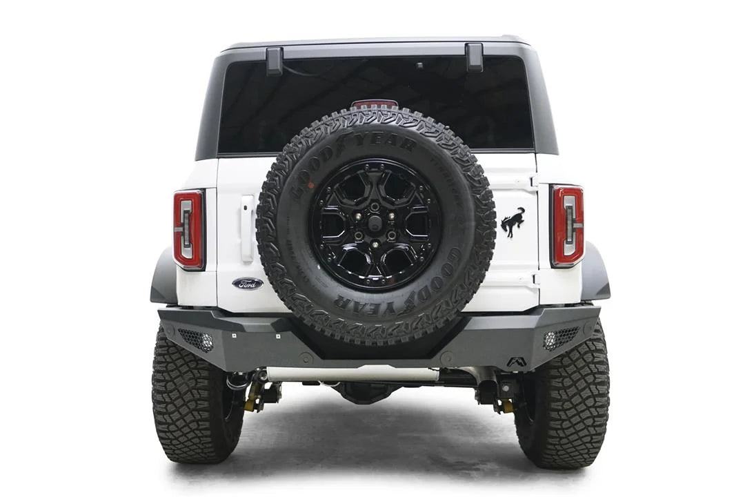Fab Fours standard rear bumper on a white Ford Bronco, straight rear view, with honeycomb mesh light openings and tailgate-mounted spare tire