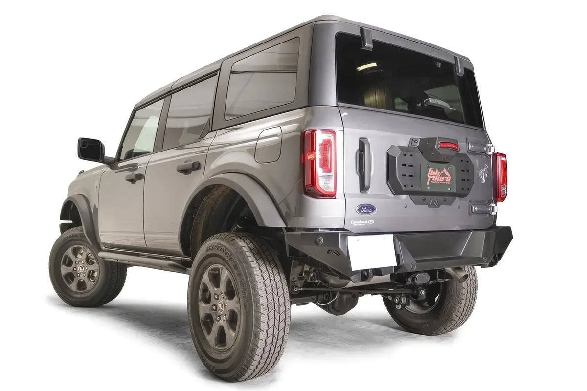 Fab Fours spare tire delete on a gray Ford Bronco, rear driver-side view, showing the bare tailgate plate with accessory mounting slots
