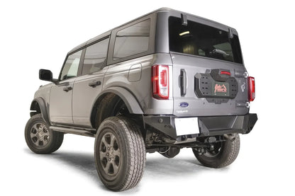 Fab Fours spare tire delete on a gray Ford Bronco, rear driver-side view, showing the bare tailgate plate with accessory mounting slots