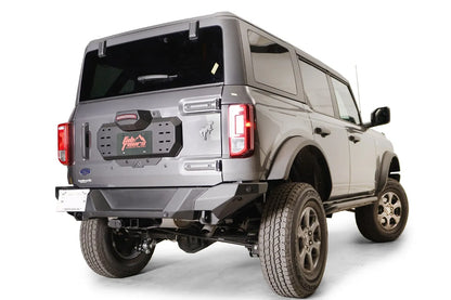 Fab Fours spare tire delete on a gray Ford Bronco, rear passenger-side view, showing the clean tailgate plate with Fab Fours license plate frame and rear bumper