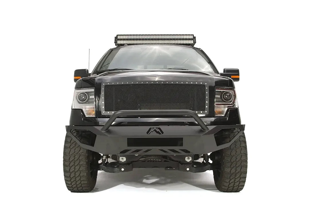 Fab Fours Vengeance front bumper with pre-runner guard on a black Ford F-150, straight-on front studio view, showing the pre-runner hoop, center logo plate and lower skid section
