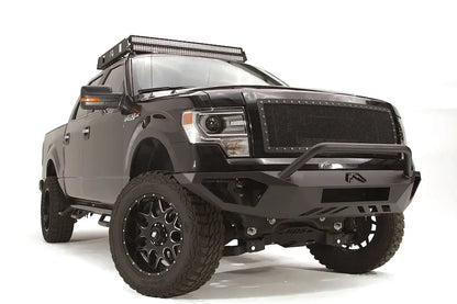 Fab Fours Vengeance front bumper with pre-runner guard on a black Ford F-150, front passenger-side three-quarter studio view, showing the pre-runner hoop, sculpted bumper face and end caps