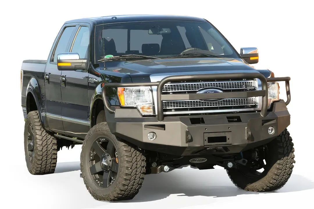 Fab Fours Premium Winch front bumper with full guard on a black Ford F-150, front passenger-side three-quarter view on a white background, showing the full grille guard, heavy-duty bumper face and fog lights
