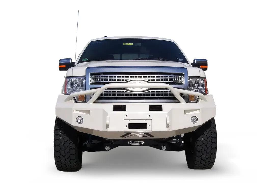 Fab Fours Premium Winch front bumper with pre-runner guard on a white Ford F-150, straight-on front view on a white background, showing the pre-runner hoop, heavy-duty bumper face and fog lights