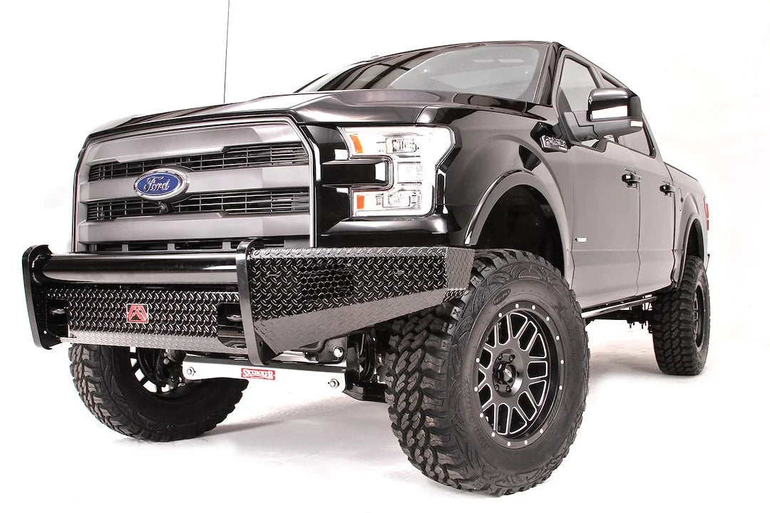 Fab Fours Black Steel front ranch bumper on a black Ford F-150, front driver-side three-quarter studio view, showing the diamond-plate bumper face, tubular top rail and wraparound wings