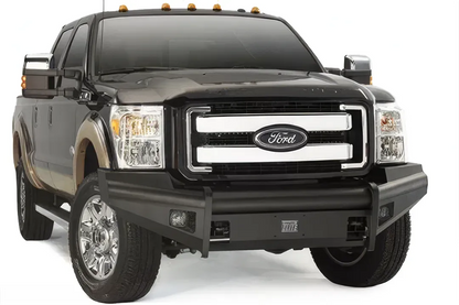 Fab Fours Black Steel Elite front bumper on a black two-tone Ford truck, front passenger-side three-quarter studio view, showing the smooth bumper face, tubular top rail and fog lights