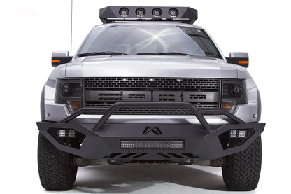 Fab Fours Vengeance front bumper with pre-runner guard on a silver Ford Raptor, straight-on front studio view, showing the pre-runner hoop, center light bar and cube light pods