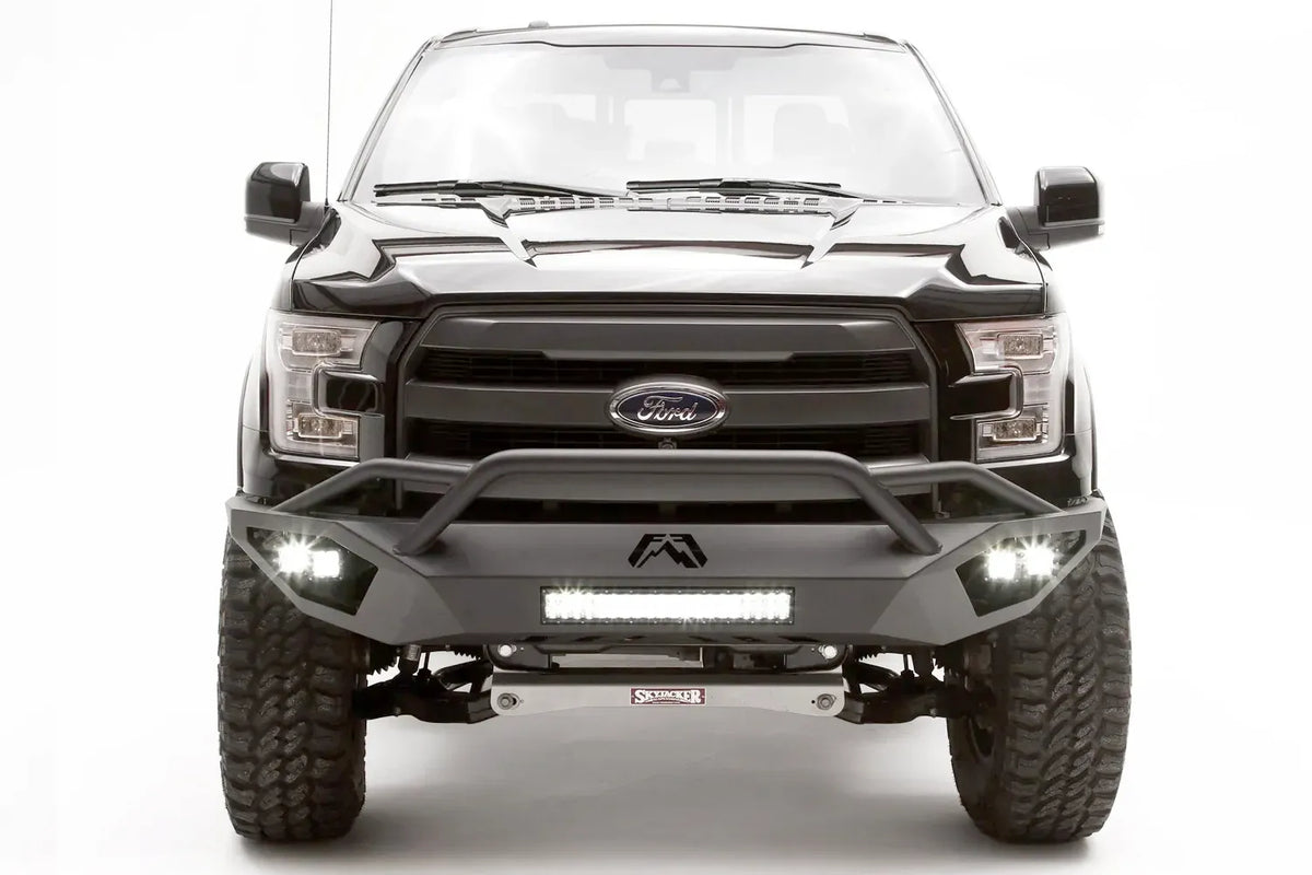 Fab Fours Vengeance front bumper with pre-runner guard on a black Ford F-150, straight-on front studio view, showing the pre-runner hoop, center light bar and cube light pods