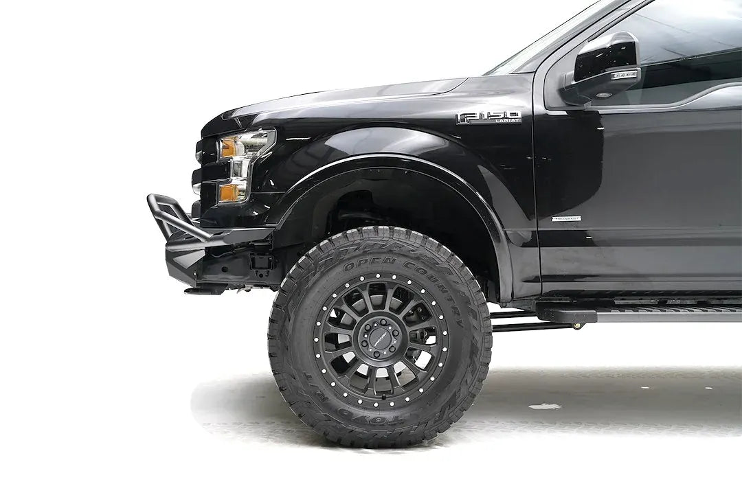 Fab Fours Aero front bumper with pre-runner guard on a black Ford F-150, close-up of the driver-side bumper end, showing the pre-runner tube, slim end cap and tire clearance