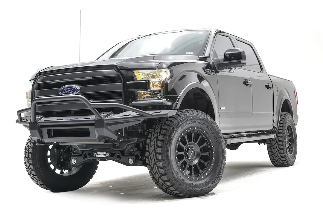 Fab Fours Aero front bumper with pre-runner guard on a black Ford F-150, front driver-side three-quarter studio view, showing the pre-runner hoop, slim bumper frame and light bar