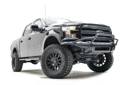 Fab Fours Aero front bumper with pre-runner guard on a black Ford F-150, front passenger-side three-quarter studio view, showing the pre-runner hoop, slim bumper frame and light bar