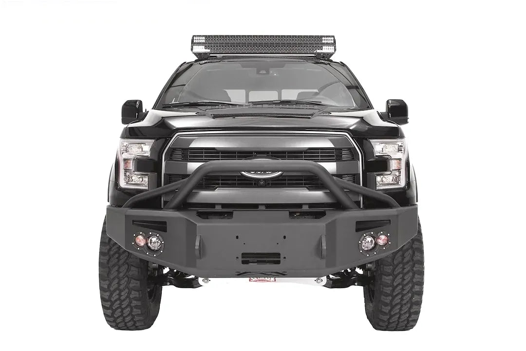 Fab Fours Premium Winch front bumper with pre-runner guard on a black Ford F-150, straight-on front studio view, showing the pre-runner hoop, winch-ready center section and round fog lights