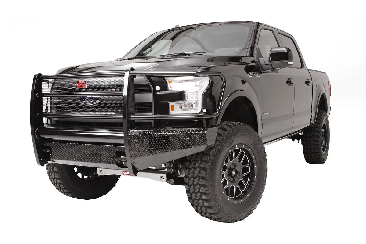 Fab Fours Black Steel front bumper with full guard on a black Ford F-150, front driver-side three-quarter studio view, showing the full grille guard, diamond-plate bumper and mesh panels
