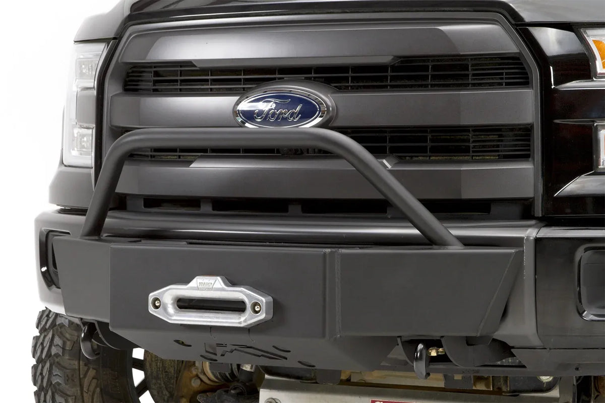 Fab Fours winch mount on a black Ford F-150, close-up front view, showing the pre-runner hoop, winch fairlead and mount plate