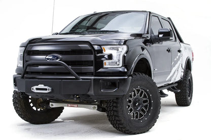 Fab Fours winch mount on a black Ford F-150, front driver-side three-quarter studio view, showing the pre-runner hoop, winch fairlead and low-profile front plate