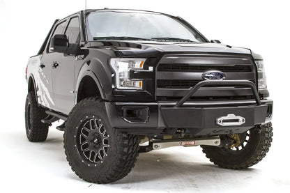Fab Fours winch mount on a black Ford F-150, front passenger-side three-quarter studio view, showing the pre-runner hoop, winch fairlead and low-profile front plate