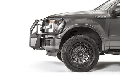 Fab Fours winch mount with full guard on a gray Ford F-150, close-up of the driver-side corner, showing the guard upright, mount plate and tire clearance