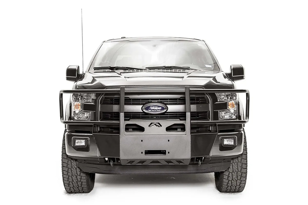 Fab Fours winch mount with full guard on a gray Ford F-150, straight-on front studio view, showing the full grille guard, center winch plate and skid section
