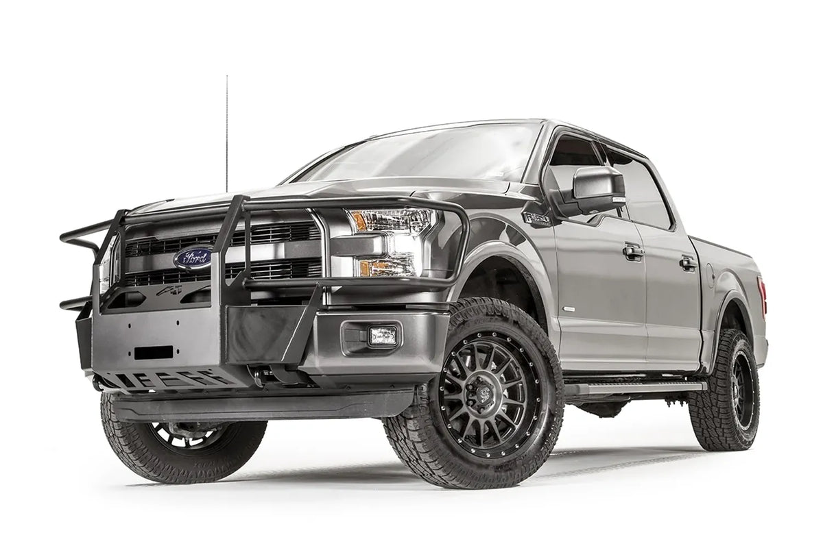 Fab Fours winch mount with full guard on a gray Ford F-150, front driver-side three-quarter studio view, showing the full grille guard, winch mount plate and skid section