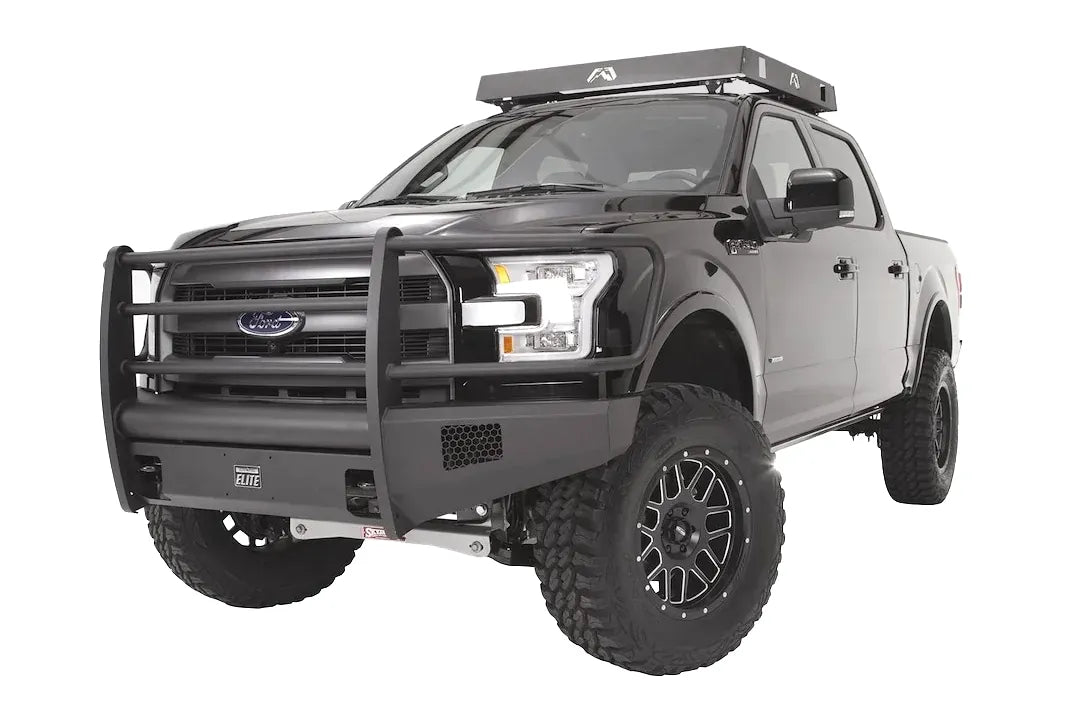 Fab Fours Black Steel Elite front bumper with full guard on a black Ford F-150, front driver-side three-quarter studio view, showing the full grille guard, smooth bumper face and side mesh vents