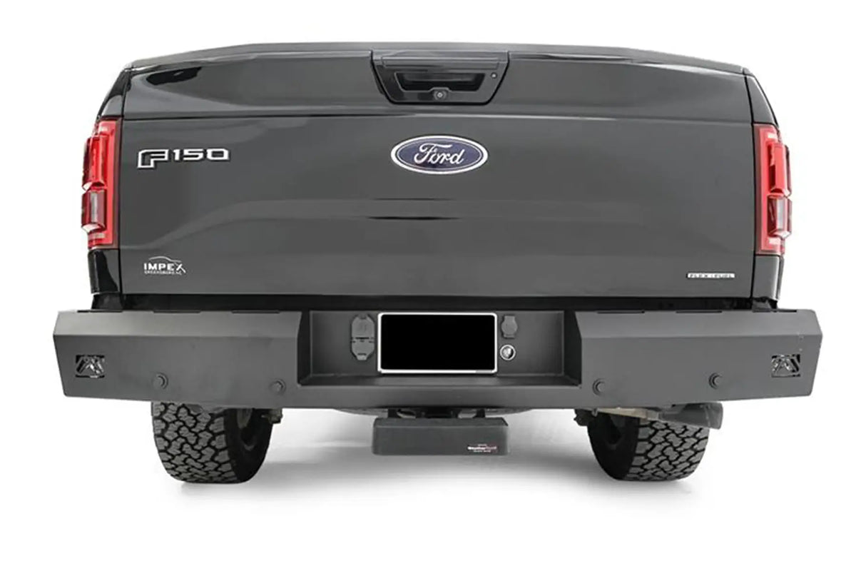 Fab Fours Red Steel rear bumper on a dark gray Ford F-150, straight-on rear view, showing the full-width bumper, integrated corner lights and centered license plate recess