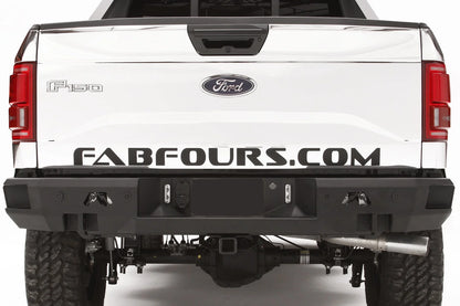 Fab Fours Premium rear bumper on a white wrapped Ford F-150, straight-on rear view, showing the logo cutouts, shackle mounts and center plate recess