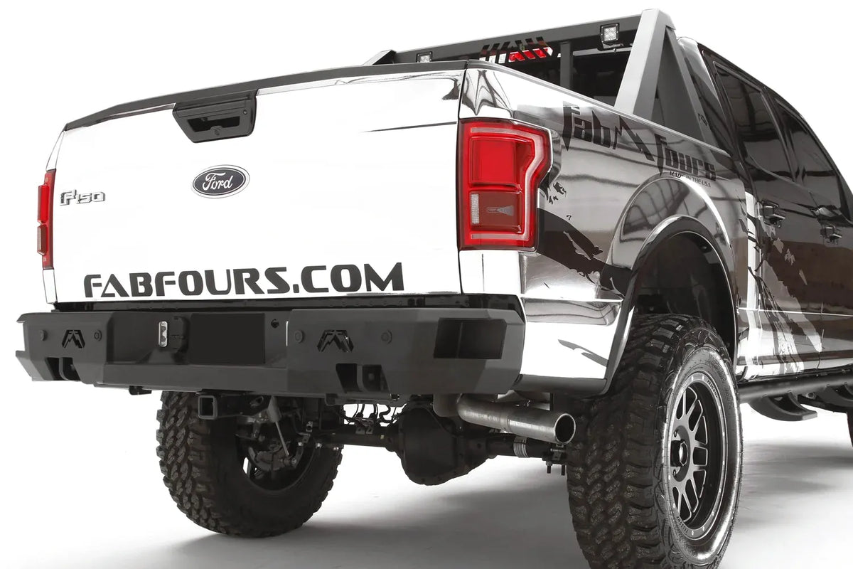Fab Fours Premium rear bumper on a white wrapped Ford F-150, rear passenger-side three-quarter view, showing the logo cutouts, center light pods and bumper end cap