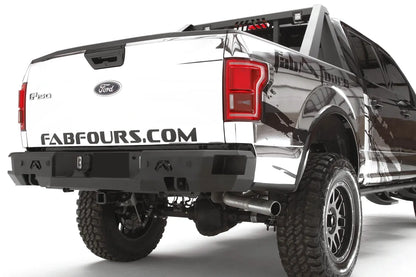 Fab Fours Premium rear bumper on a white wrapped Ford F-150, rear passenger-side three-quarter view, showing the logo cutouts, center light pods and bumper end cap