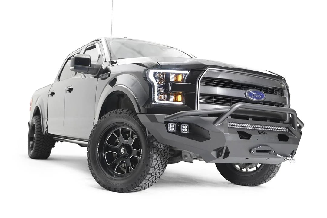 Fab Fours Matrix front bumper with pre-runner guard on a black Ford F-150, front passenger-side three-quarter view, showing the pre-runner hoop, light bar and winch
