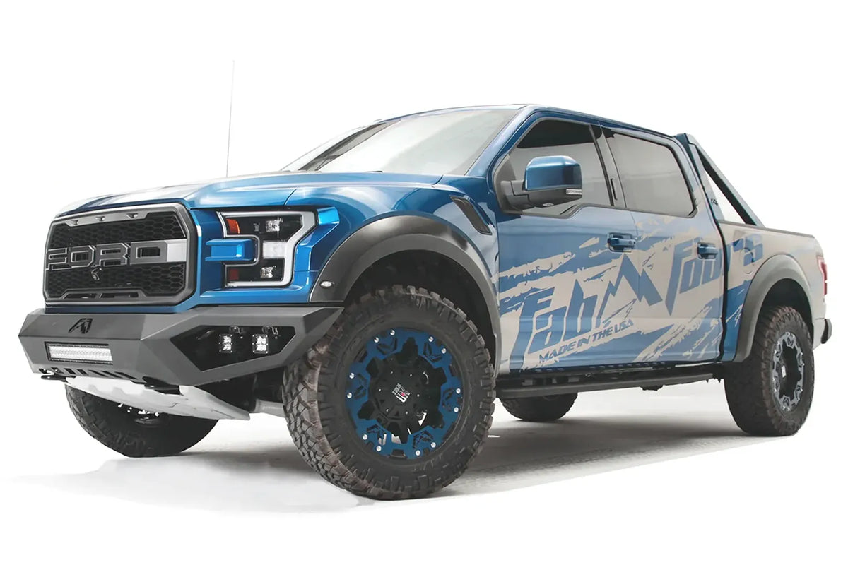 Fab Fours Vengeance front bumper on a blue and gray wrapped Ford Raptor, front driver-side three-quarter view, showing the light bar, cube light pods and angled end caps