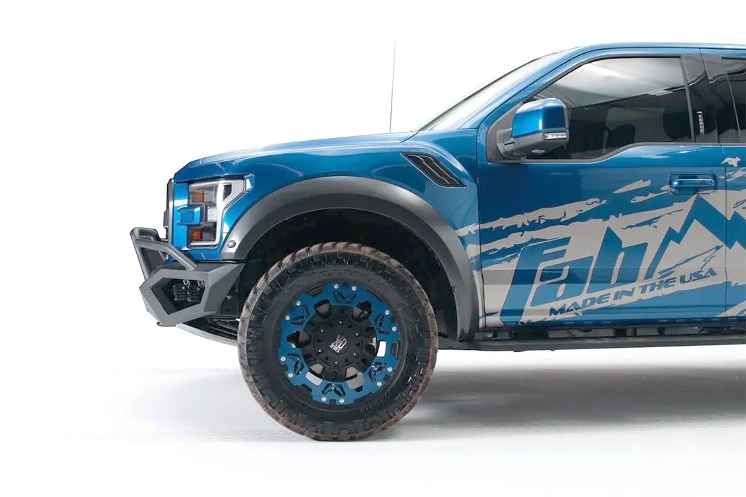 Fab Fours Vengeance front bumper with pre-runner guard on a blue and gray wrapped Ford Raptor, driver-side profile view, showing the pre-runner tube and bumper end