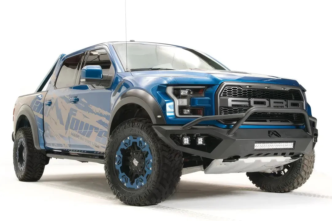Fab Fours Vengeance front bumper with pre-runner guard on a blue and gray wrapped Ford Raptor, front passenger-side three-quarter view, showing the pre-runner hoop, light bar and cube lights
