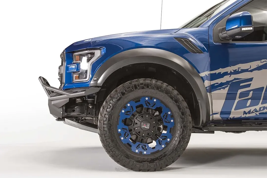 Fab Fours Aero front bumper with pre-runner guard on a blue Ford F-150 Raptor, driver-side profile view of the bumper end and front wheel