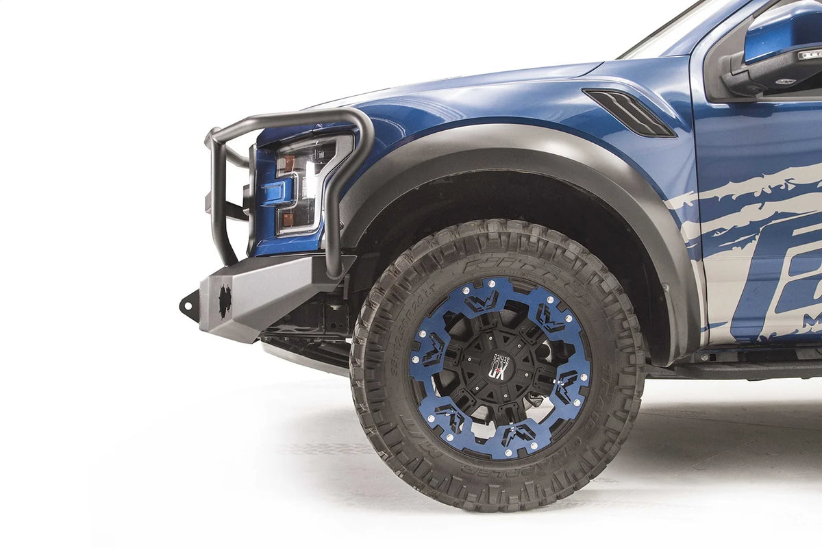 Fab Fours Premium Winch front bumper with full guard on a blue and gray wrapped Ford Raptor, close-up of the front corner, showing the guard upright, bumper end and shackle mount