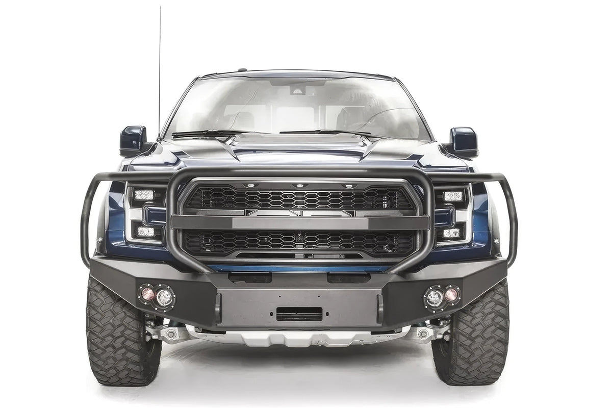 Fab Fours Premium Winch front bumper with full guard on a blue and gray wrapped Ford Raptor, straight-on front view, showing the full grille guard, center winch recess and round fog lights