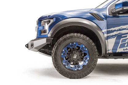 Fab Fours Premium Winch front bumper on a blue and gray wrapped Ford Raptor, close-up of the front corner, showing the bumper end, shackle mount and wheel clearance