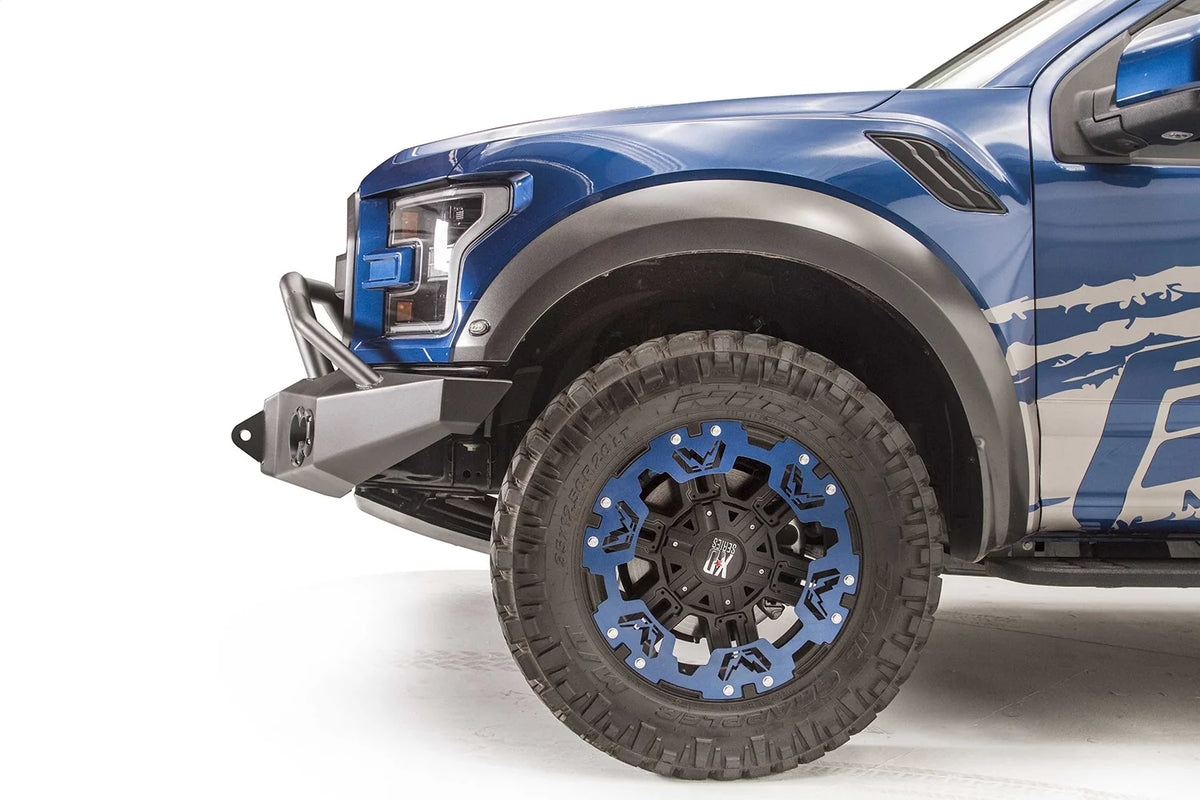 Fab Fours Premium Winch front bumper with pre-runner guard on a blue and gray wrapped Ford Raptor, close-up of the front corner, showing the pre-runner tube, bumper end and shackle mount
