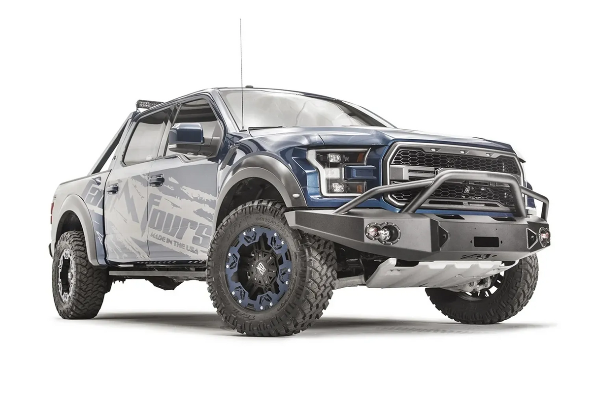 Fab Fours Premium Winch front bumper with pre-runner guard on a blue and gray wrapped Ford Raptor, front passenger-side three-quarter view, showing the pre-runner hoop, winch recess and round fog lights