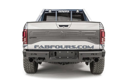 Fab Fours Premium rear bumper on a silver and navy wrapped Ford Raptor, straight-on rear view, showing the logo cutouts, center plate recess and exhaust openings