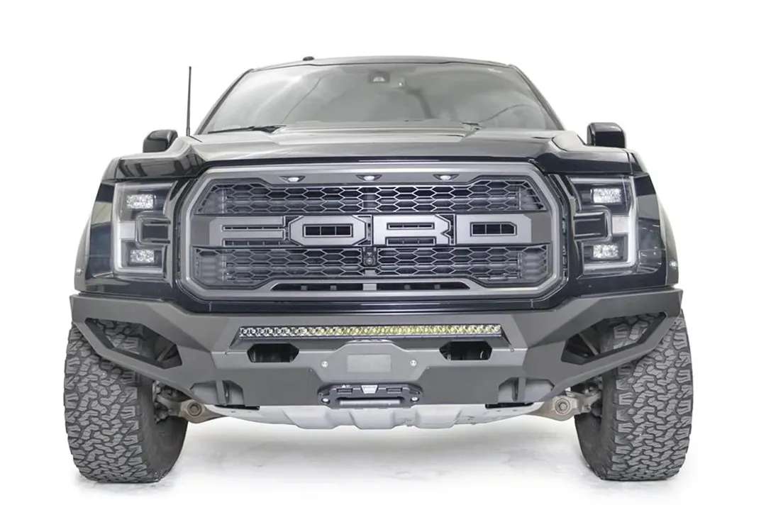 Fab Fours Matrix front bumper on a black Ford Raptor, straight-on front view, showing the center light bar, winch fairlead and cube light openings