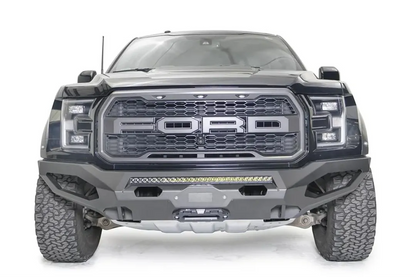 Fab Fours Matrix front bumper on a black Ford Raptor, straight-on front view, showing the center light bar, winch fairlead and cube light openings