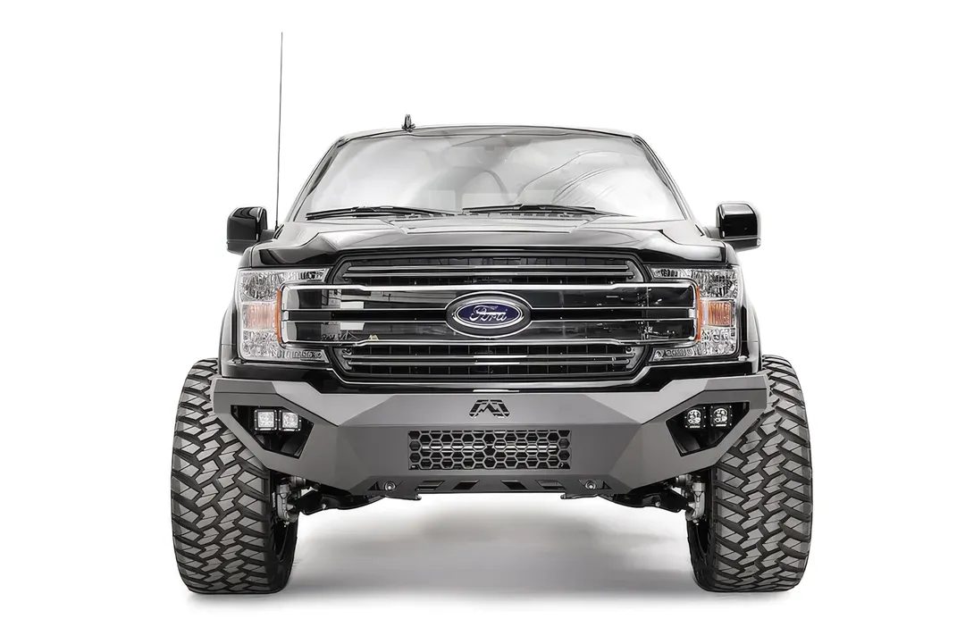Fab Fours Vengeance front bumper on a black Ford F-150, straight-on front view, showing the mesh center panel, cube light pods and Fab Fours logo