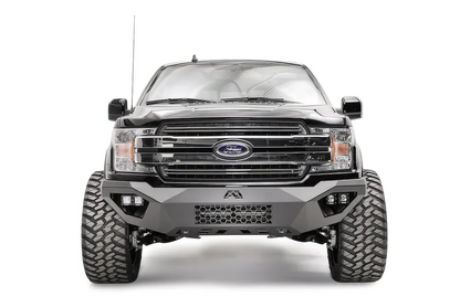 Fab Fours Vengeance front bumper on a black Ford F-150, straight-on front view, showing the mesh center panel, cube light pods and Fab Fours logo