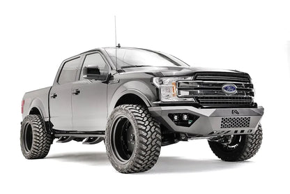 Fab Fours Vengeance front bumper on a black Ford F-150, front passenger-side three-quarter view, showing the mesh center panel, cube light pods and angled end caps